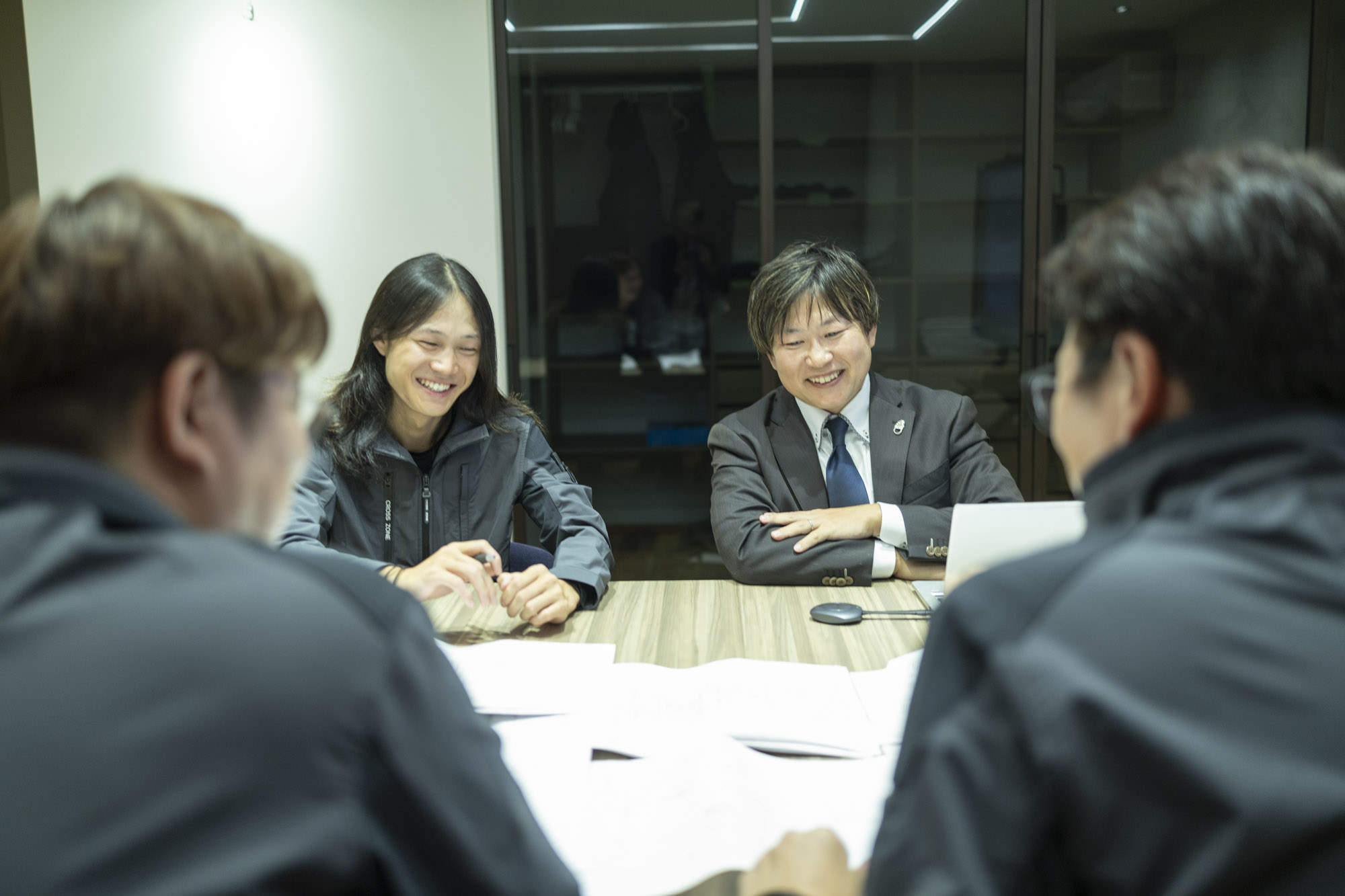 会議室で図面を囲んで打ち合わせをする居藤電機の社員