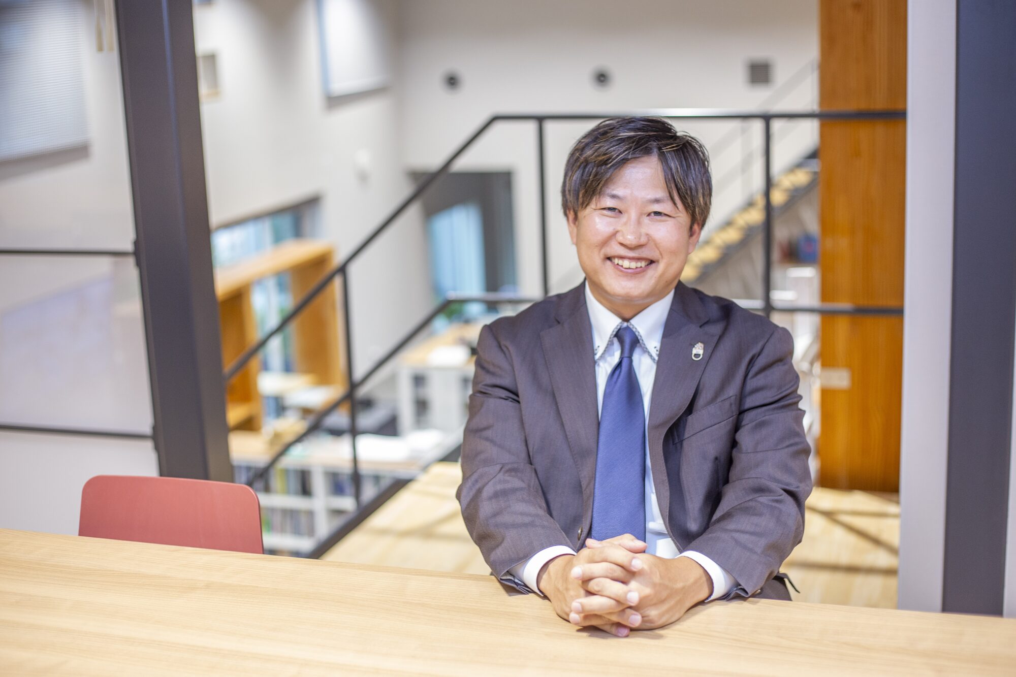 事務所の打ち合わせテーブルでインタビューに答える代表取締役 居藤正人